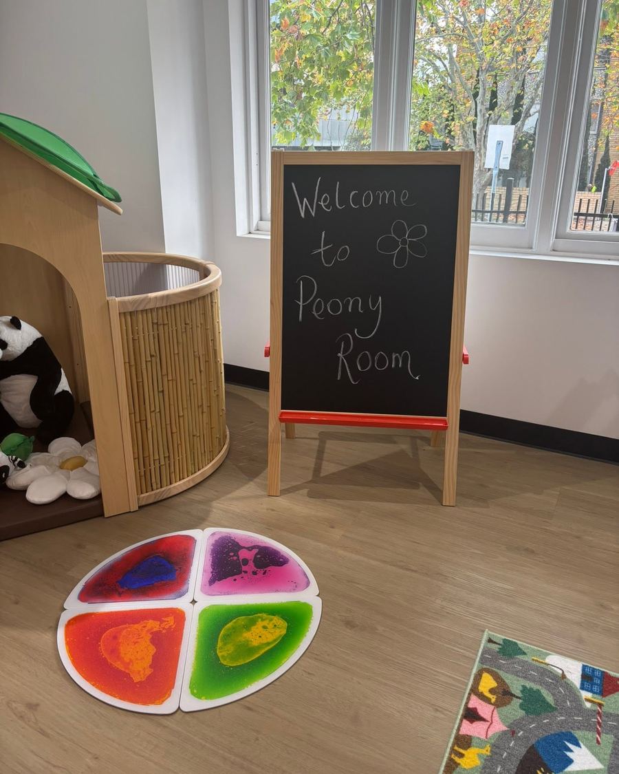 A chalkboard reading Welcome to Peony Room beside a timber cubby